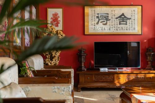 a living room with a flat screen tv and a couch at Datong Yunzhong Traditional Courtyard in Datong