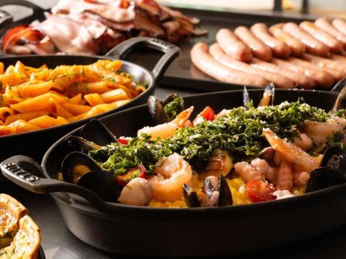a table topped with trays of vegetables and other foods at the square hotel KANAZAWA in Kanazawa