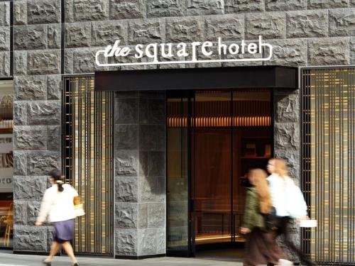 a group of people walking in front of a building at the square hotel KANAZAWA in Kanazawa