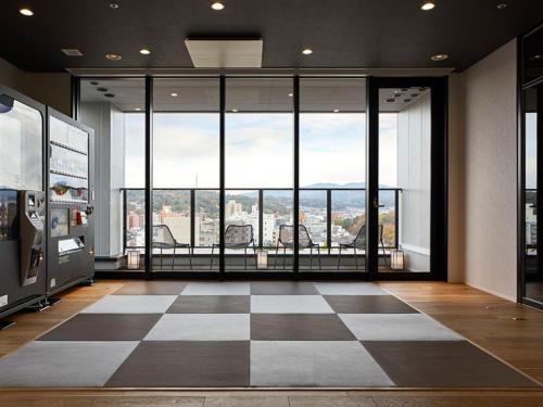 a room with a checkered floor and large windows at the square hotel KANAZAWA in Kanazawa