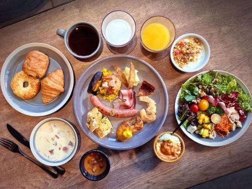 a wooden table with plates of food on it at the square hotel KANAZAWA in Kanazawa