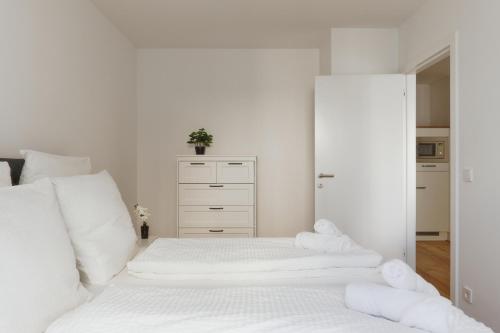 a white bedroom with white sheets and towels on a bed at Symphony Apartments Vienna - Garden, Terrace and Grill in Vienna