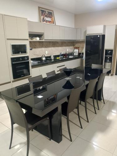 a kitchen with a black and white counter and chairs at Casa Blanca in Belém