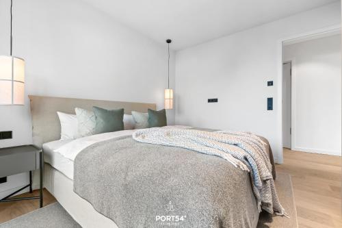 a white bedroom with a large bed and a desk at Brooklyn Bridge Suite List auf Sylt in List