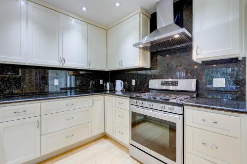 a kitchen with white cabinets and a stove top oven at Urban Oasis next to Santana Row in San Jose