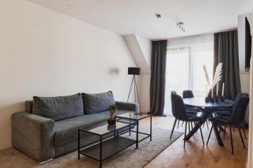 a living room with a couch and a table at Symphony Apartments Vienna - Garden, Terrace and Grill in Vienna