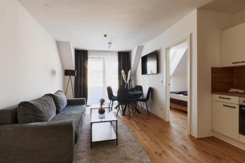 a living room with a couch and a table at Symphony Apartments Vienna - Garden, Terrace and Grill in Vienna