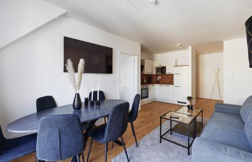 a living room with a table and a blue couch at Symphony Apartments Vienna - Garden, Terrace and Grill in Vienna