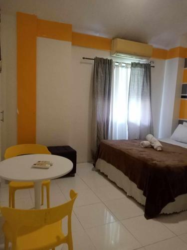 a bedroom with a bed and a table and a window at HOST HOMES near AIRPORT BETA BAYVIEW in Burayan