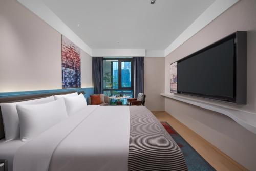 a hotel room with a bed and a flat screen tv at CityNote Hotel -Guangzhou Beijing Road Pedestrian Street Yuexiu Park Branch in Guangzhou