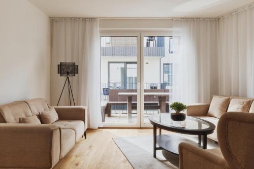 a living room with a couch and a table at Symphony Apartments Vienna - Garden, Terrace and Grill in Vienna