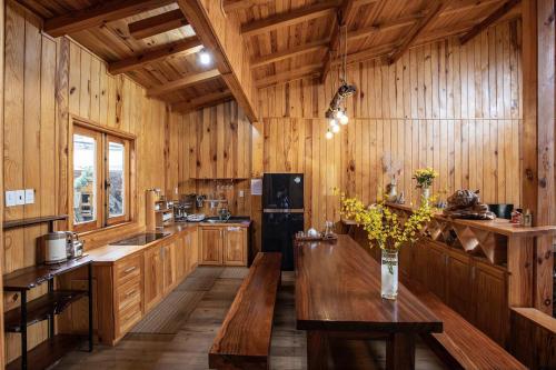 a kitchen with wooden walls and a table with flowers on it at Khai Quynh Villa 3 - Venuestay in Khu Chi Lăng