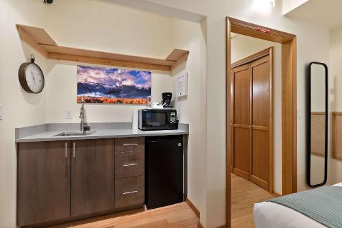 a small kitchen with a sink and a microwave at Snowcreek Suite - Aspen - Hot Tub - Kitchenette in Leavenworth
