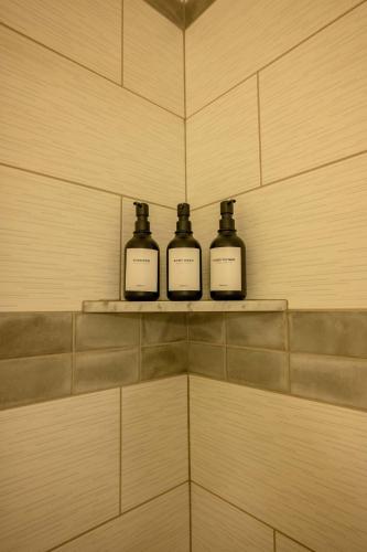 three bottles sitting on a shelf in a bathroom at Snowcreek Suite - Aspen - Hot Tub - Kitchenette in Leavenworth