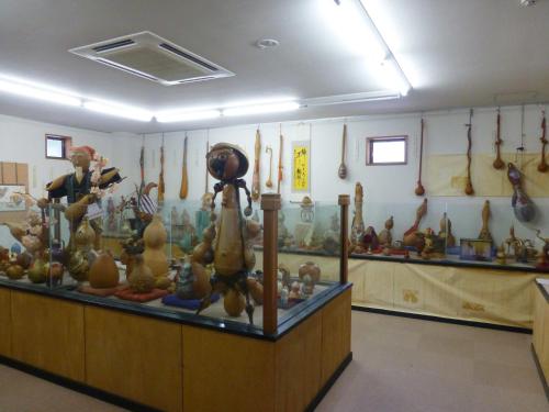 a display case in a room filled with lots of vases at 咲花温泉 ホテル丸松 in Gosen