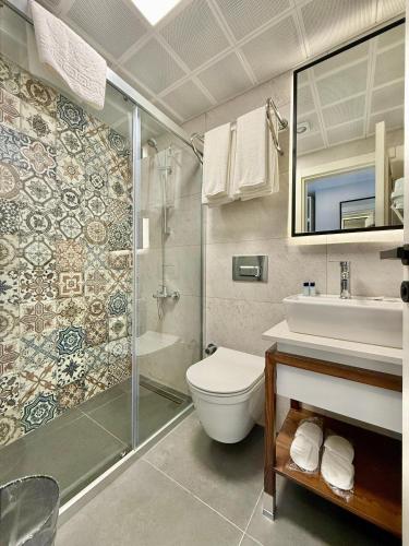 a bathroom with a shower and a toilet and a sink at Adria Inn in Antalya