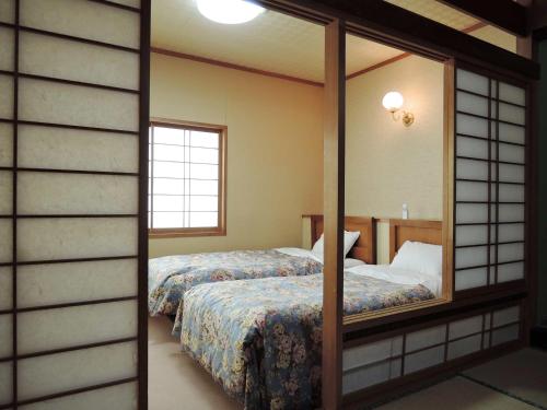 Postel nebo postele na pokoji v ubytování 咲花温泉 ホテル丸松