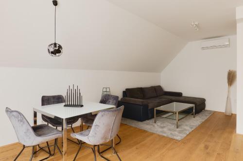 a living room with a table and chairs and a couch at Symphony Apartments Vienna - Garden, Terrace and Grill in Vienna