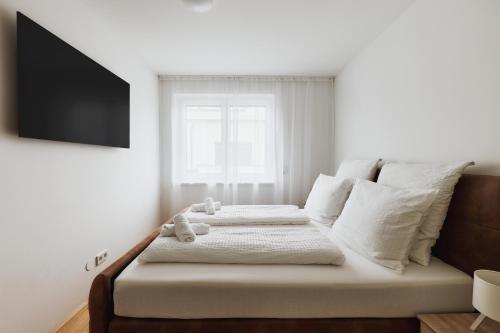 a bedroom with a bed with a television on the wall at Symphony Apartments Vienna - Garden, Terrace and Grill in Vienna