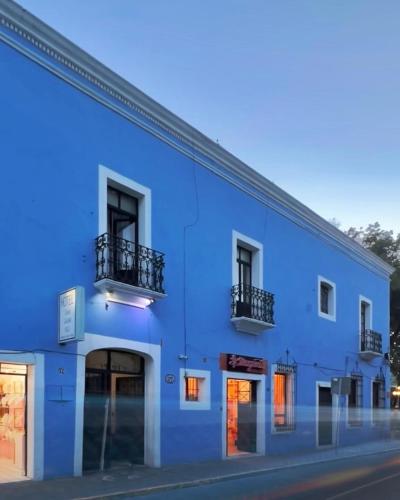 a blue building with windows and balconies on a street at Hotel Boutique Casa Catalá in Tlaxcala de Xicohténcatl