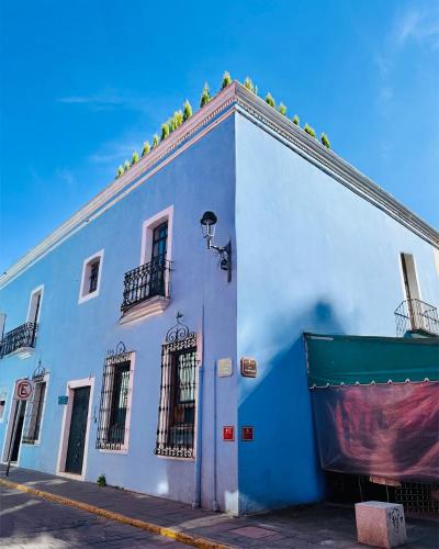 a blue and white building with plants on the roof at Hotel Boutique Casa Catalá in Tlaxcala de Xicohténcatl