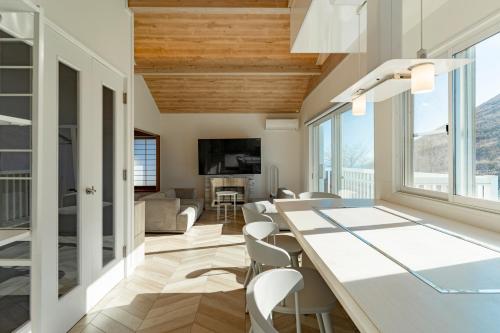 a dining room and living room with a table and chairs at COCO VILLA 大室山 -Izu Omuroyama- in Futo
