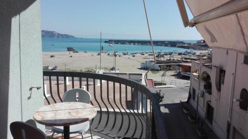 a balcony with a table and a view of a beach at Kalaskiso' in Giardini Naxos