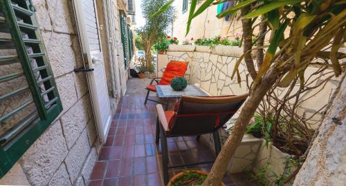 a patio with chairs and a table and a plant at Dubrovnik center apartment in Dubrovnik