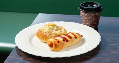 a paper plate with two hot dogs and a cup of coffee at 桑名シティホテル in Kuwana