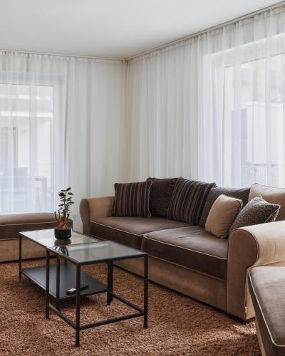 a living room with a couch and a table at Symphony Apartments Vienna - Garden, Terrace and Grill in Vienna