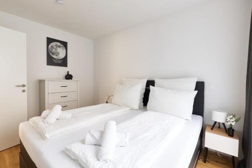 a bedroom with two beds with white sheets and pillows at Symphony Apartments Vienna - Garden, Terrace and Grill in Vienna