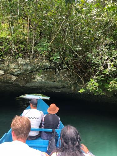 a group of people in a boat going through a cave at Korbekwan Homestay in Besir