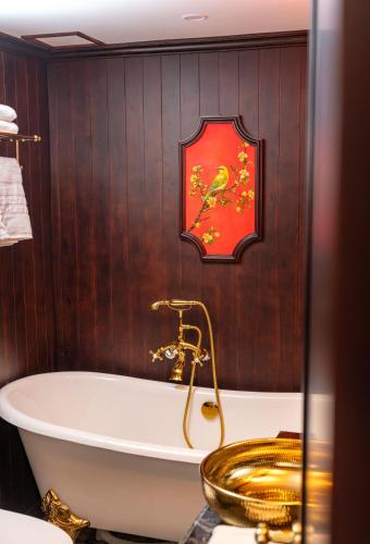 a bathroom with a tub and a red clock on the wall at Indochine Grand Lan Ha Bay in Ha Long
