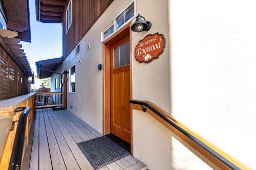 a sign on the side of a building with a wooden door at Snowcreek Suite - Dogwood - Hot tub - Kitchenette in Leavenworth