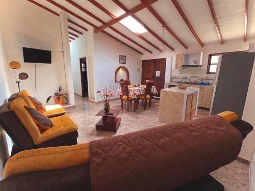 a living room with a couch and a kitchen at Apartahotel Sacrosanta Trinidad in Villa de Leyva