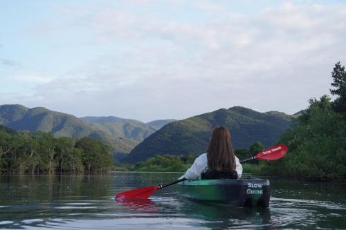 a woman sitting in a kayak on a river at Coral Palms in Amami