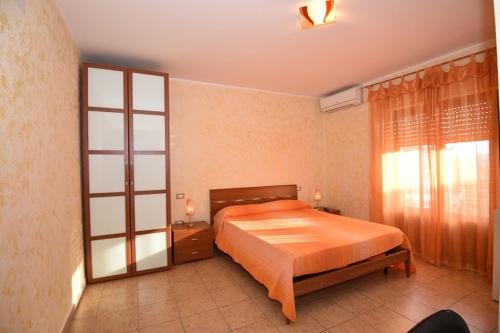 een slaapkamer met een bed en een groot raam bij Sa Marina in La Caletta