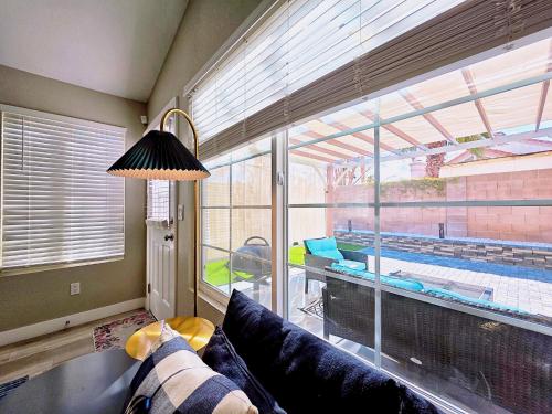 a living room with a couch and a large window at Near the Strip, Smart TVs, WiFi, private garage and backyard in Las Vegas