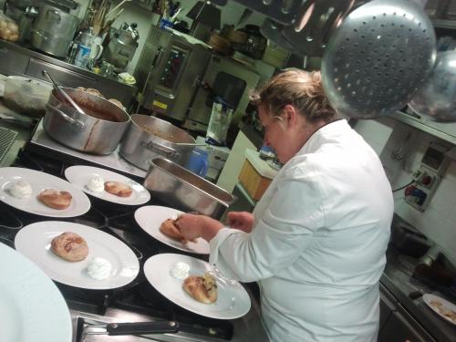 a woman in a kitchen preparing food on plates at Hotel Danieli La Castellana lago di Garda in Brenzone sul Garda