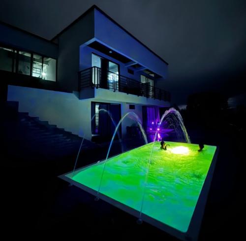 a house with a pool with people in it at night at Birdhouse85 - Casa campestre in Alcalá