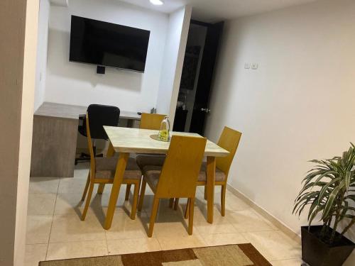 Un comedor con mesa y sillas y un televisor. en Excellent studio apartment!, en Ibagué