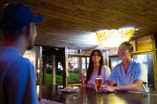 a group of people sitting at a table in a bar at Coral Palms in Amami