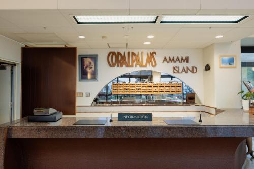a lobby with a counter with a sign that readsauts armament stand at Coral Palms in Amami