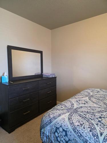 a bedroom with a dresser with a mirror on it at Humble Home in Aurora