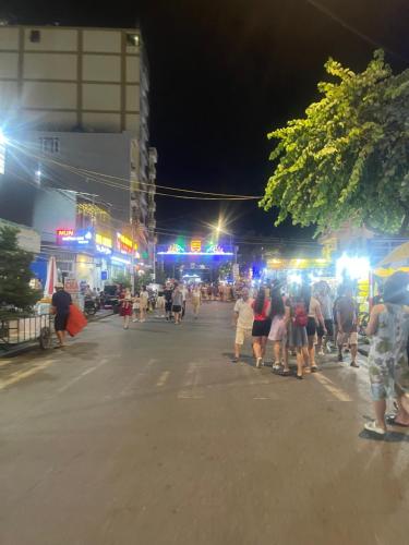 a group of people walking down a street at night at Nhà Nghỉ Biển Xanh in Dao Co To