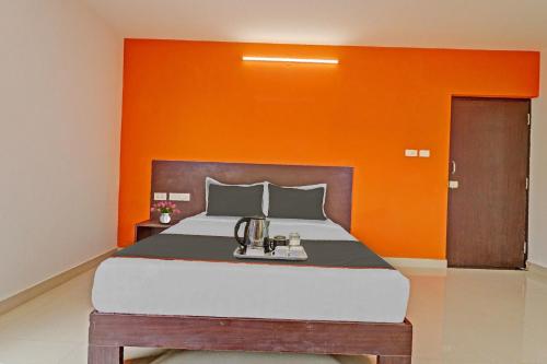 a bedroom with a large bed with an orange wall at The Blooms stay inn in Bengaluru