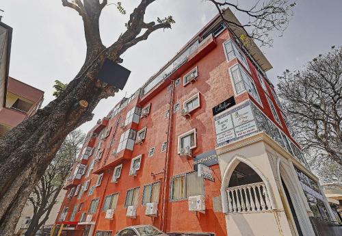 a red brick building with a tree next to it at The Blooms stay inn in Bengaluru