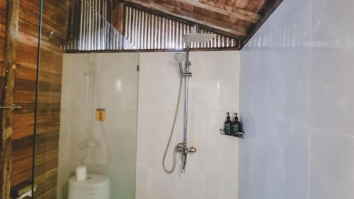 a bathroom with a shower with a toilet and a shower at Aura Guesthouse in Ubud
