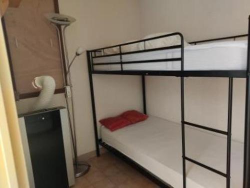 une chambre avec deux lits superposés et une lampe dans l'établissement Location T2 Gruissan : Piscine, Parking, Clim, Proche Plage - Idéal Famille - FR-1-796-1, à Gruissan