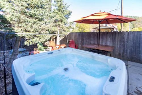 a hot tub in a backyard with an umbrella at Snowcreek Suite - Cedar - ADA- Hot Tub - Kitchenette in Leavenworth